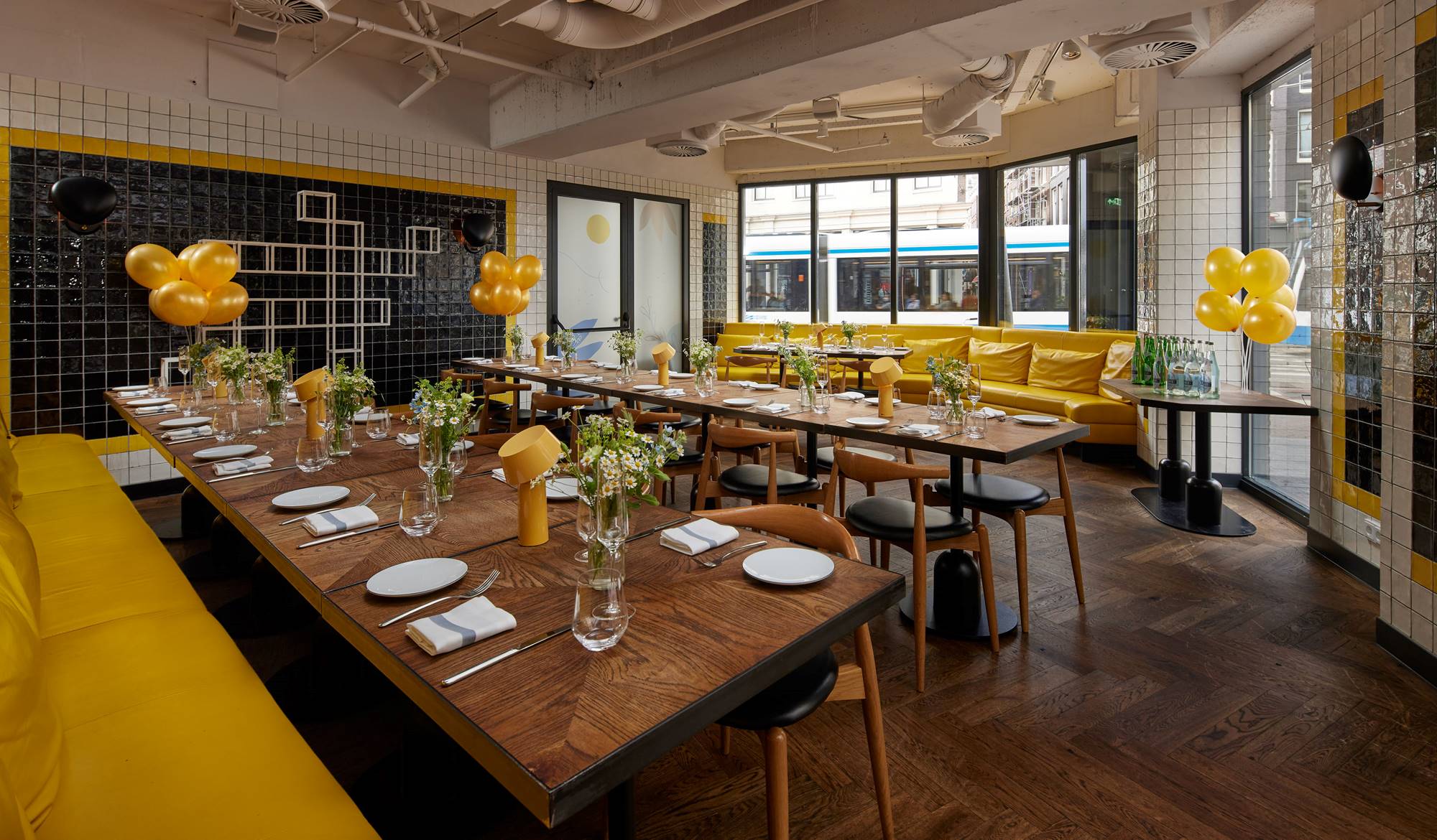 A colorful dining setup for a celebration with yellow balloons and flower arrangements decorates Celia’s bright dining area.